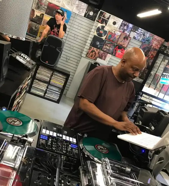 DJ at the turntables in a record shop